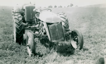 Ford tractor after having flipped over. Behind it is a 1948 Case tractor.